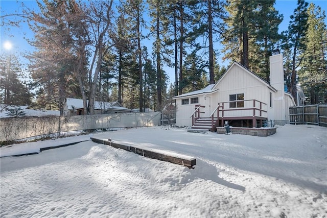 exterior space featuring a fenced backyard, a chimney, and a wooden deck