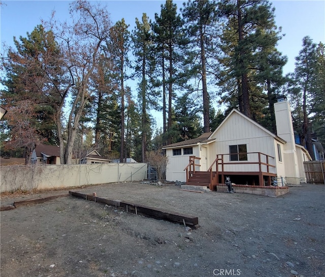 1131 Apple Ave, Wrightwood, CA 92397 - view of front of home with a chimney, board and batten siding, a wooden deck, and fence