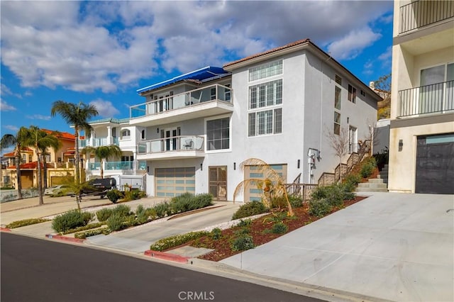 view of front of property with an attached garage, concrete driveway, and stucco siding