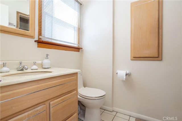 bathroom featuring baseboards, vanity, toilet, and tile patterned floors