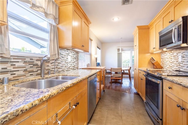 kitchen featuring light brown cabinetry, appliances with stainless steel finishes, a sink, and visible vents