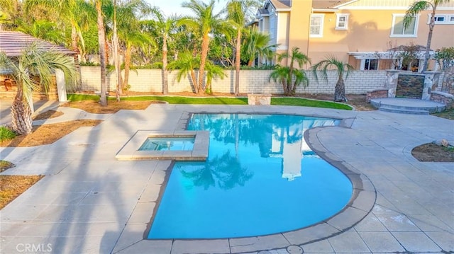 view of swimming pool with a patio area, fence, and a pool with connected hot tub