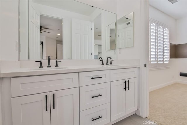 full bathroom with double vanity, a sink, and baseboards