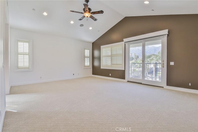 empty room featuring light carpet, plenty of natural light, baseboards, and vaulted ceiling