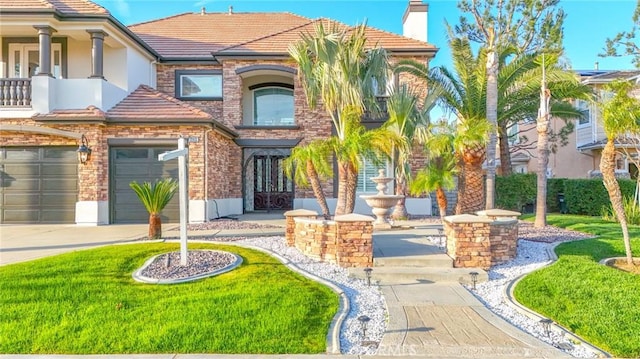 view of front of house with an attached garage, a tiled roof, concrete driveway, and a balcony