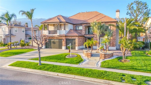 view of front of property with a tile roof, an attached garage, a front yard, a mountain view, and driveway