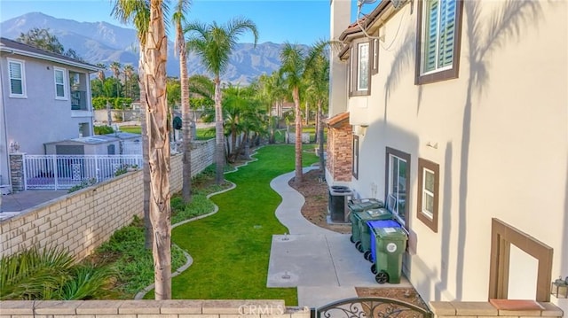 view of yard featuring a patio, cooling unit, a fenced backyard, and a mountain view