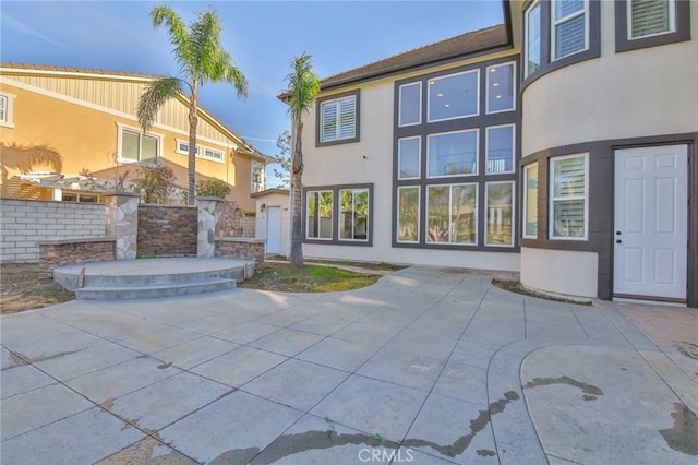 rear view of house with a patio area and stucco siding