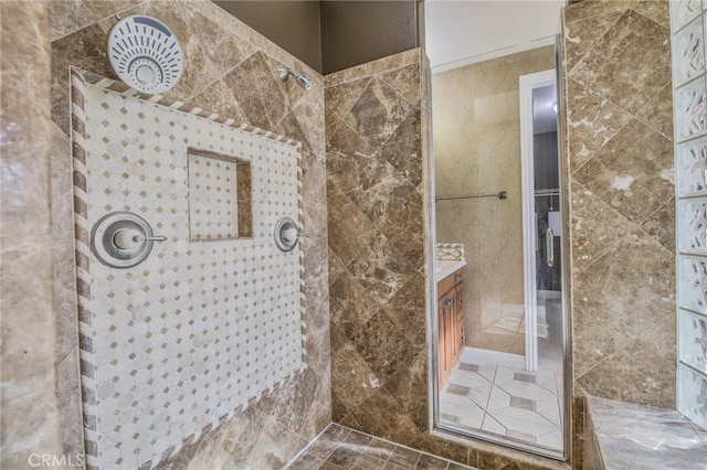 full bathroom featuring tiled shower and vanity