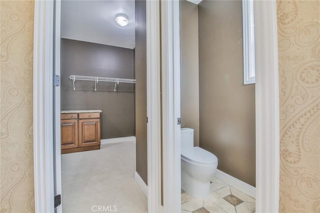 bathroom featuring toilet and baseboards