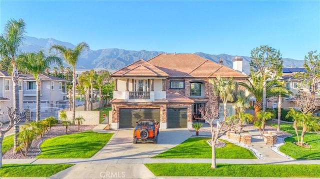 view of front facade featuring a balcony, a mountain view, a garage, concrete driveway, and a front lawn