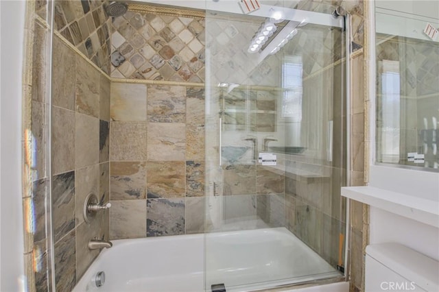 bathroom featuring combined bath / shower with glass door and toilet