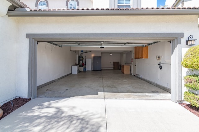 garage with driveway and secured water heater