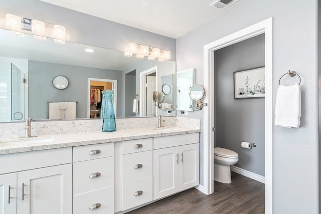 bathroom featuring a spacious closet, a stall shower, a sink, and visible vents