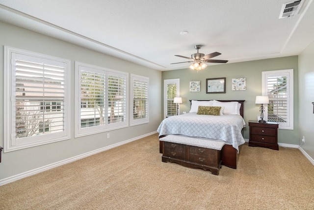 bedroom featuring light carpet, baseboards, visible vents, and ceiling fan