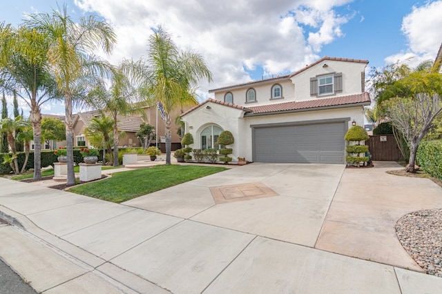 mediterranean / spanish-style house featuring a garage, driveway, a tile roof, and stucco siding