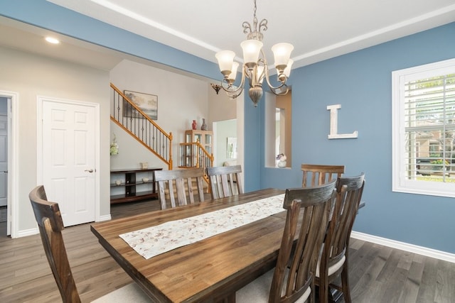 dining space with stairs, baseboards, wood finished floors, and a chandelier