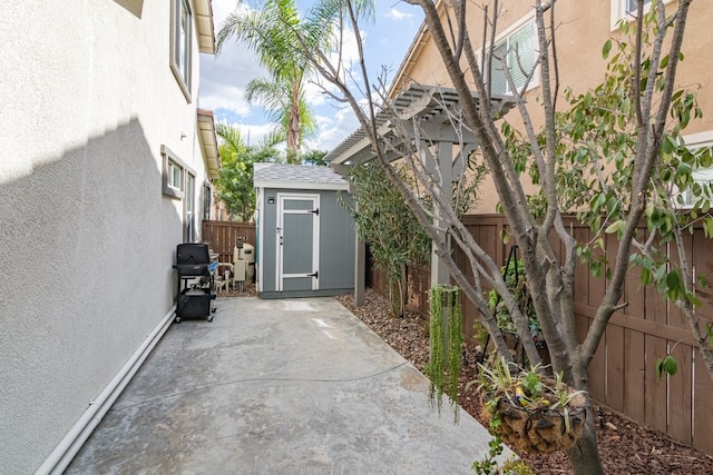 view of patio / terrace featuring a storage unit, grilling area, an outdoor structure, and a fenced backyard