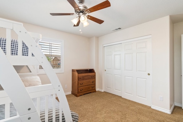 carpeted bedroom with a closet, visible vents, ceiling fan, and baseboards