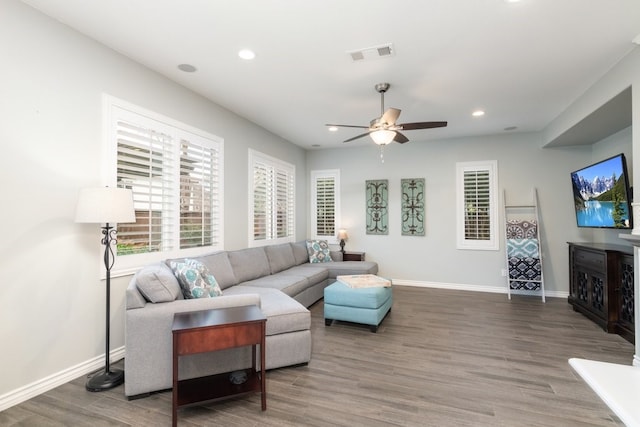 living area with recessed lighting, wood finished floors, visible vents, and baseboards