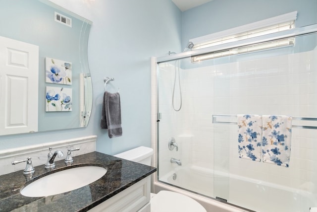 full bath featuring enclosed tub / shower combo, visible vents, vanity, and toilet