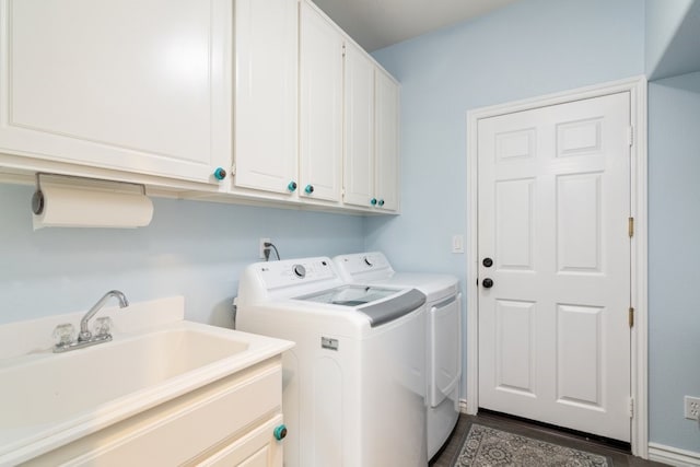 clothes washing area featuring cabinet space, washer and clothes dryer, and a sink