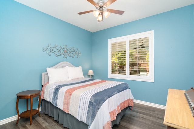 bedroom with ceiling fan, wood finished floors, and baseboards