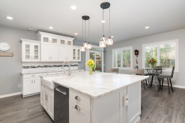 kitchen featuring dishwashing machine, wood finished floors, backsplash, and a sink