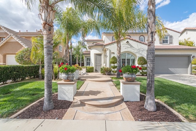 mediterranean / spanish-style house featuring a garage, concrete driveway, a front lawn, and stucco siding