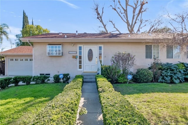 view of front of house featuring an attached garage, a front yard, and stucco siding