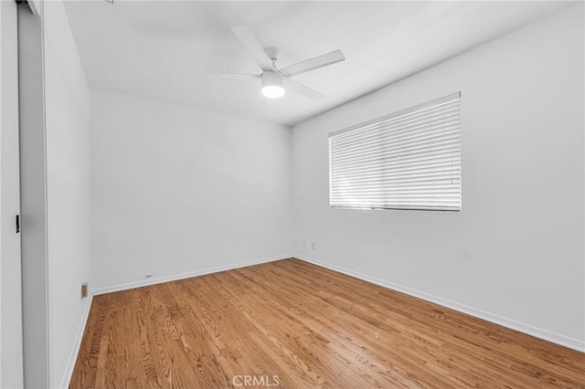 unfurnished room featuring light wood finished floors, baseboards, and a ceiling fan