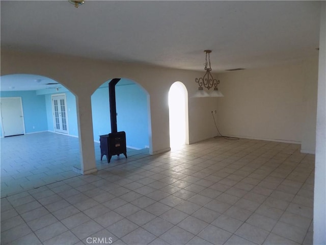 unfurnished room with light tile patterned floors, visible vents, and arched walkways