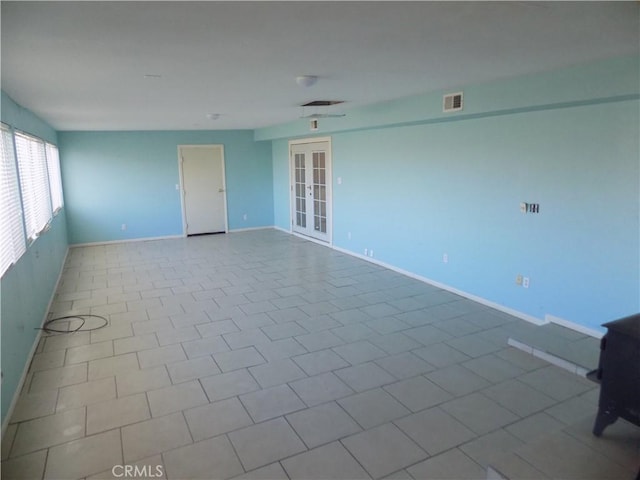 spare room with visible vents, french doors, and baseboards