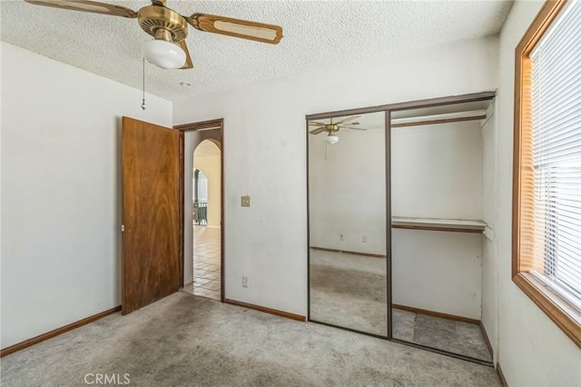 11671 Jacaranda Ave, Hesperia, CA 92345 - unfurnished bedroom with a ceiling fan, a textured ceiling, arched walkways, a closet, and carpet flooring