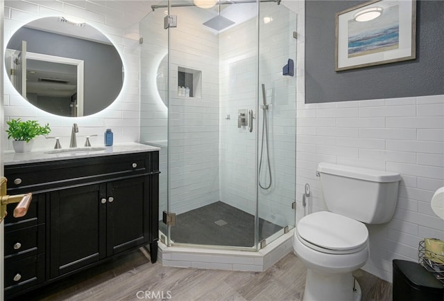 full bath with vanity, tile walls, toilet, and wood finished floors