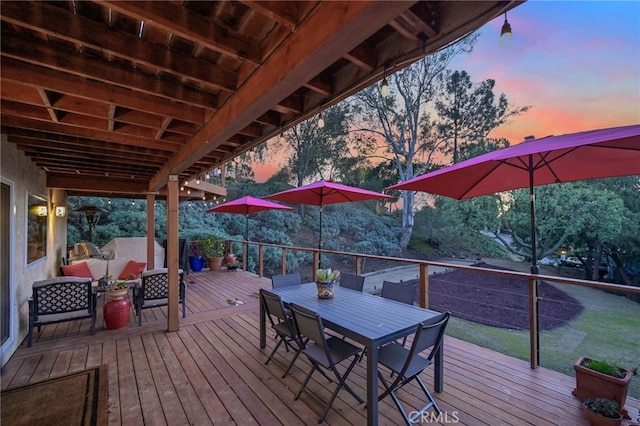 deck at dusk featuring outdoor dining space