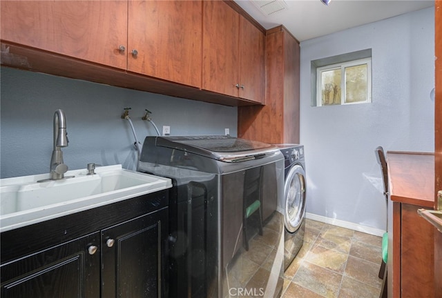 laundry area featuring separate washer and dryer, a sink, visible vents, baseboards, and cabinet space