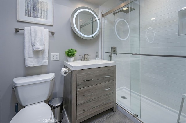 full bathroom with toilet, a stall shower, wood finished floors, and vanity