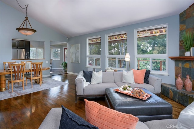 living area featuring lofted ceiling, baseboards, and wood finished floors