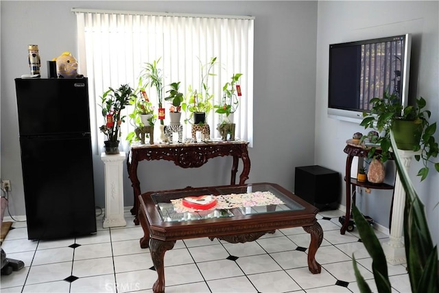 living area featuring baseboards and light tile patterned floors