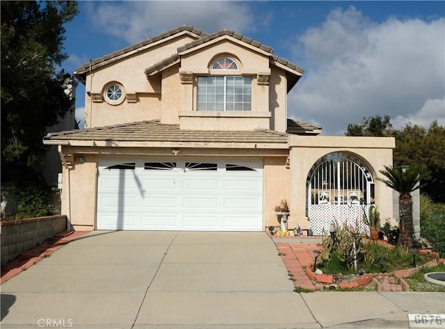 mediterranean / spanish home with a garage, concrete driveway, a tile roof, and stucco siding