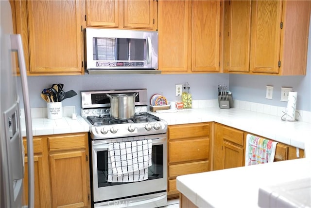 kitchen with appliances with stainless steel finishes and tile counters