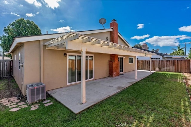 rear view of property featuring central air condition unit, a fenced backyard, a patio, and stucco siding