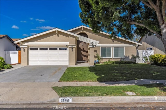 view of front of house featuring a garage, driveway, fence, a front lawn, and stucco siding