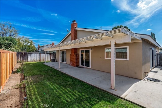 back of property with a lawn, a patio area, a fenced backyard, and stucco siding