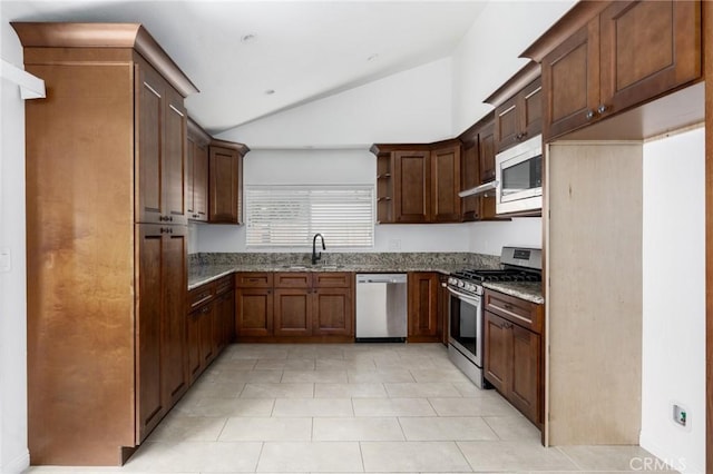 kitchen featuring dark stone counters, appliances with stainless steel finishes, vaulted ceiling, open shelves, and a sink