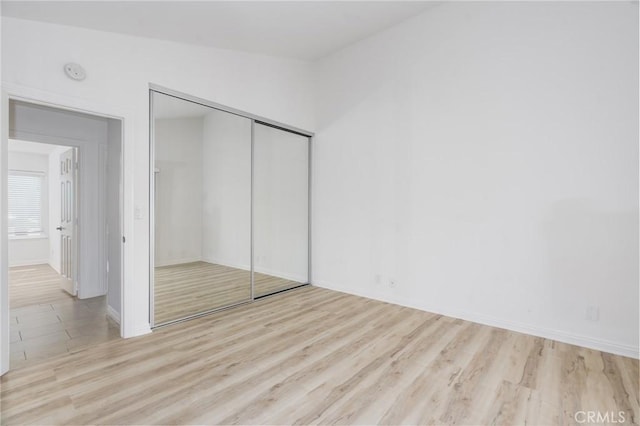 unfurnished bedroom with a closet and wood finished floors