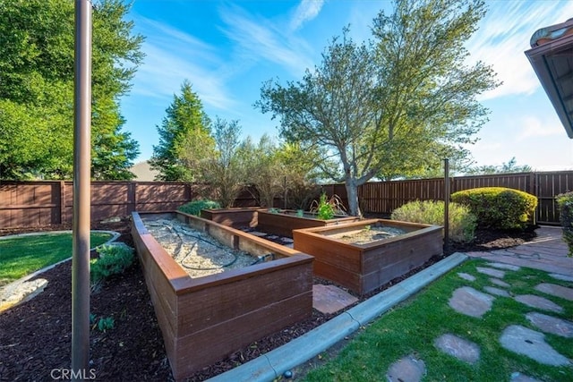 exterior space with a garden and a fenced backyard