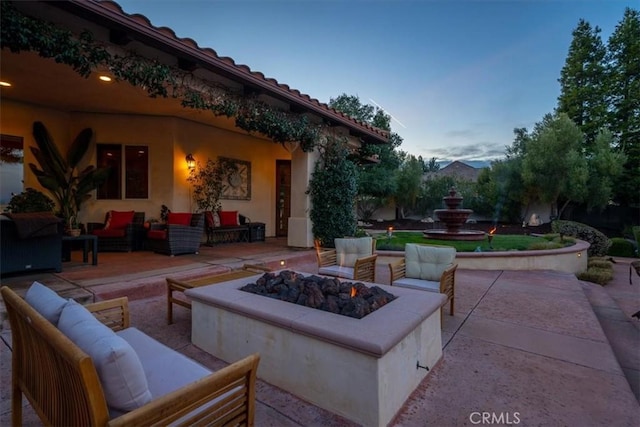 patio terrace at dusk with an outdoor living space with a fire pit