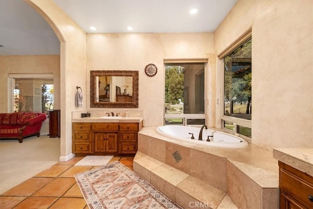 bathroom featuring tile patterned flooring, a garden tub, vanity, and recessed lighting